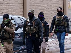 immigration and customs enforcement ice agents including one wearing a not ice face covering walk near their vehicles thursday jan 15 2026 in richfield minn