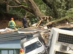 in this image from a video a police officer with dog searches people near the site of a landlide at the base of mount maunganui on new zealand s north island thursday jan 22 2026