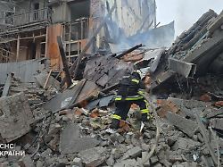 in this photo provided by the ukrainian emergency service emergency services personnel work to extinguish a fire following a russian missile attack in kharkiv ukraine friday jan 2 2026