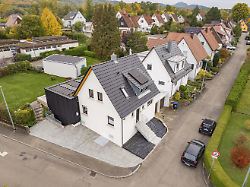 luftaufnahme einer ruhigen wohnstrasse mit modernisiertem haus und anbau eingebettet in herbstliche gaerten haus renovierung klima sanierung metzingen deutschland