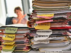 mehrere stapel mit akten liegen auf einem tisch am finanzgericht berlin brandenburg