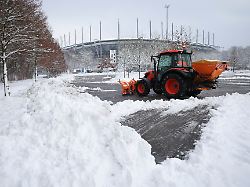 mit einem kleinen traktor und schneeraeumschild befreit ein mitarbeiter einen teil des parkplatz rot am volksparkstadion vom schnee