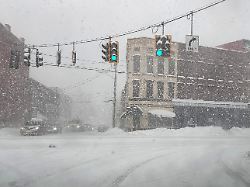 neuschnee weht ueber eine kreuzung in lowville