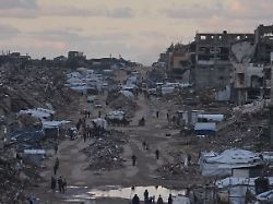 palaestinenser gehen an zerstoerten gebaeuden im noerdlichen gazastreifen