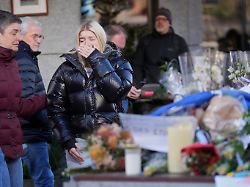 people bring flowers near the sealed off le constellation bar where a devastating fire left dead and injured during the new year s celebrations in crans montana swiss alps switzerland friday jan 2 2026