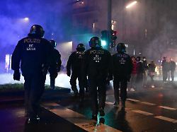 polizeibeamte gehen waehrend der silvesternacht in neukoelln ueber eine strasse