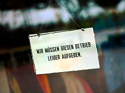 schild an der glastuer eines geschaefts mit der aufschrift wir muessen diesen betrieb leider aufgeben fotomontage