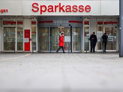 security mitarbeiter stehen vor der nach dem spektakulaeren einbruch weiterhin geschlossenen filiale der sparkasse gelsenkirchen eine passantin geht davor entlang