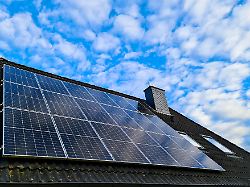 solarmodule bedecken das dach eines wohnhauses unter einem strahlend blauen himmel und nutzen erneuerbare energie