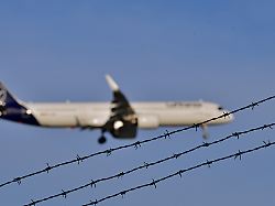 symbolbild abschiebung flugzeug fliegt hinter stacheldraht