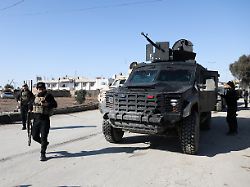 syrian democratic forces sdf fighters walk near an armored vehicle following clashes between sdf and syrian government forces in hasakah syria january 20 2026