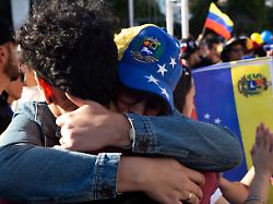 two people hug each other during celebrations by venezuelan residents in argentina over the us intervention in venezuela carrying flags of both countries in buenos aires argentina on january 3 2026