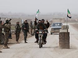 a man rides a motorcycle and raises the syrian flag next to a syrian army checkpoint on the outskirts of the city of al hasakah syria february 2 2026