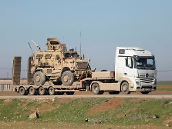 a trailer carries an armoured u s military vehicle as u s troops move towards the iraqi kurdistan region withdrawing from qasrak military base in northeastern syria in qamishli syria february 23 2026