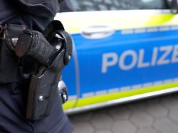 archiv 15 03 2024 hamburg ein polizist steht vor einem einsatzfahrzeug der polizei