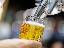 am stand der finnischen maelzerei viking malt auf der getraenkemesse braubeviale zapft ein mitarbeiter ein bier