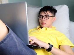 an asian young man is working from home during coronavirus or covid 19 quarantine coronavirus covid 19 infected patient in coronavirus covid 19 quarantine room using computer