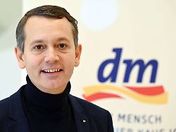 christoph werner vorsitzender der geschaeftsfuehrung der drogeriemarktkette dm aufgenommen vor beginn der jahrespressekonferenz des drogeriekonzerns vor einem dm logo