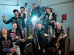 die band steht zu einem pressefoto hinter der buehne auftritt der band druckluft mit ihrem hit karnevalsmaus in der stadthalle koeln muelheim