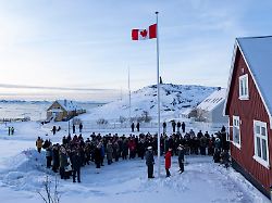die kanadische aussenministerin anita anand im vordergrund mitte hilft beim hissen der kanadischen flagge im neuen kanadischen konsulat in nuuk