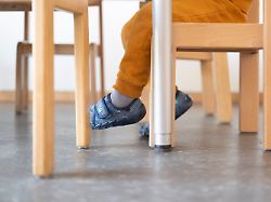 ein kind wartet in einer tageseinrichtung fuer kinder auf sein mittagessen