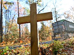 ein kreuz fuer eine verkehrstote steht am rand einer strasse