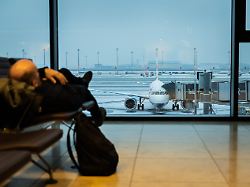 ein mann liegt mit sicht auf den schneebedeckten hauptstadtflughafen ber im terminal am flughafen ber ist der flugverkehr aufgrund der witterung eingestellt worden