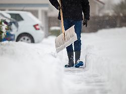 ein mann schippt und raeumt schnee weg