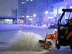 ein schneeraeumfahrzeug der bsr buerstet den schnee vom vereisten boden am alexanderplatz