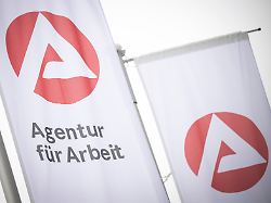 eine fahne mit dem logo der agentur fuer arbeit weht im wind