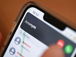 eine hand haelt ein smartphone auf dem ein anonymer anrufer angezeigt wird gestellte szene