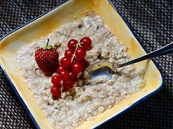 eine schale porridge mit obst auf dem fruehstueckstisch