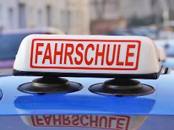 kosten fuer einen fuehrerschein fahrschule schild auf einem pkw symbolbild