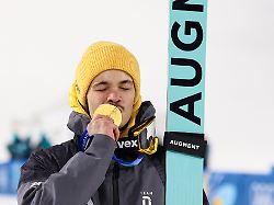 predazzo italien 09 februar 2026 skispringen einzel normalschanze maenner olympia 2026 im bild philipp raimund ger kuesst als olympiasieger die goldmedaille