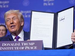 president donald trump holds up a signed resolution during a board of peace meeting at the u s institute of peace thursday feb 19 2026 in washington