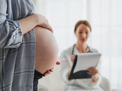 schwangere frau haende beruehren grossen bauch im arztbuero frauenarzt untersucht schwangere frau gynaekologe arztberatung patienten ueber schwangerschaft im krankenhaus