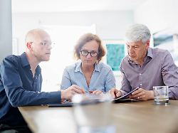 symbolfoto zum thema beratung eine aeltere frau und ein aelterer mann sitzen zu hause zusammen an einem tisch und werden von einem jungen mann beraten berlin 13 08 2024