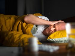 thema schmerzen mann liegt im bett