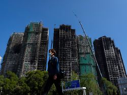 dpatopbilder 06 02 2026 hongkong ein fussgaenger geht an den vom feuer zerstoerten wohntuermen des wang fuk court apartmentkomplexes im tai po viertel von hongkong vorbei