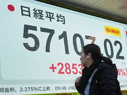 dpatopbilder 09 02 2026 japan tokio eine person geht vor einer elektronischen boersentafel die den japanischen nikkei index anzeigt
