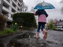 14 03 2026 nordrhein westfalen bonn ein kind laeuft mit gummistiefeln durch eine pfuetze waehrend die ersten pflanzen ihre blueten zeigen bringt das wochenende in nordrhein westfalen regen