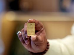 a jewelry shop owner shows a gold nugget at his store in lucknow india thursday aug 7 2025