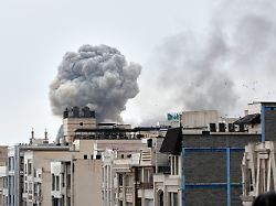 a plume of smoke rises after a strike in tehran iran tuesday march 2 2026