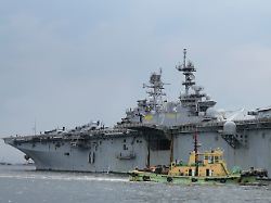 a tugboat passes by a u s navy uss tripoli lha 7 amphibious assault ship during a port call in manila philippines tuesday sept 27 2022