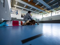 archiv 03 10 2024 nordrhein westfalen muenster ein student sitzt in einer turnhalle auf einer isomatte