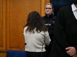 archiv 19 12 2025 baden wuerttemberg heilbronn eine angeklagte steht mit dem ruecken zum saal vor dem erneuten beginn ihres prozesses am landgericht heilbronn