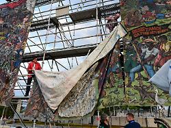 archiv 21 06 2022 hessen kassel documenta mitarbeiter bauen das umstrittene grossbanner people s justice des indonesischen kuenstlerkollektivs taring padi auf dem friedrichsplatz ab