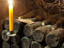 alte weinflaschen im weinkeller mit kerze