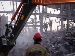 an iranian firefighter and a loader work on the ruins of a police headquarters that is completely destroyed in u s israeli attacks in tehran iran on march 2 2026