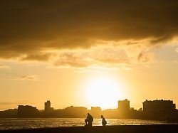 angler sind auf der uferpromenade malecon bei sonnenaufgang waehrend eines stromausfalls in havanna unterwegs
